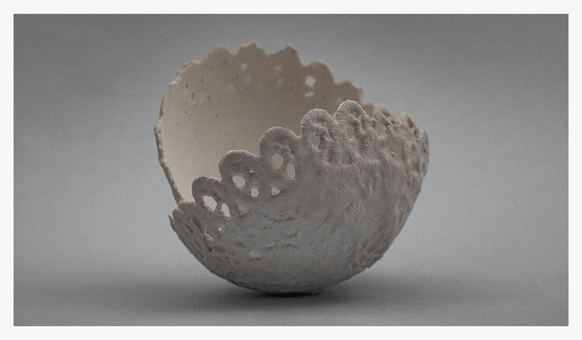 A textured, white ceramic bowl resembling a lace doily, sitting on a light gray background.
